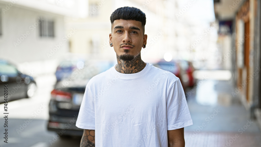 Obraz premium Young latin man standing with serious expression at street