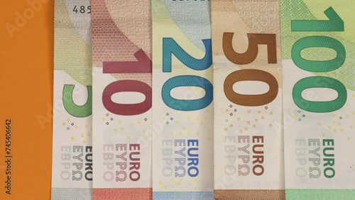 Euro banknotes transition on orange paper background. 4K stop motion animation.