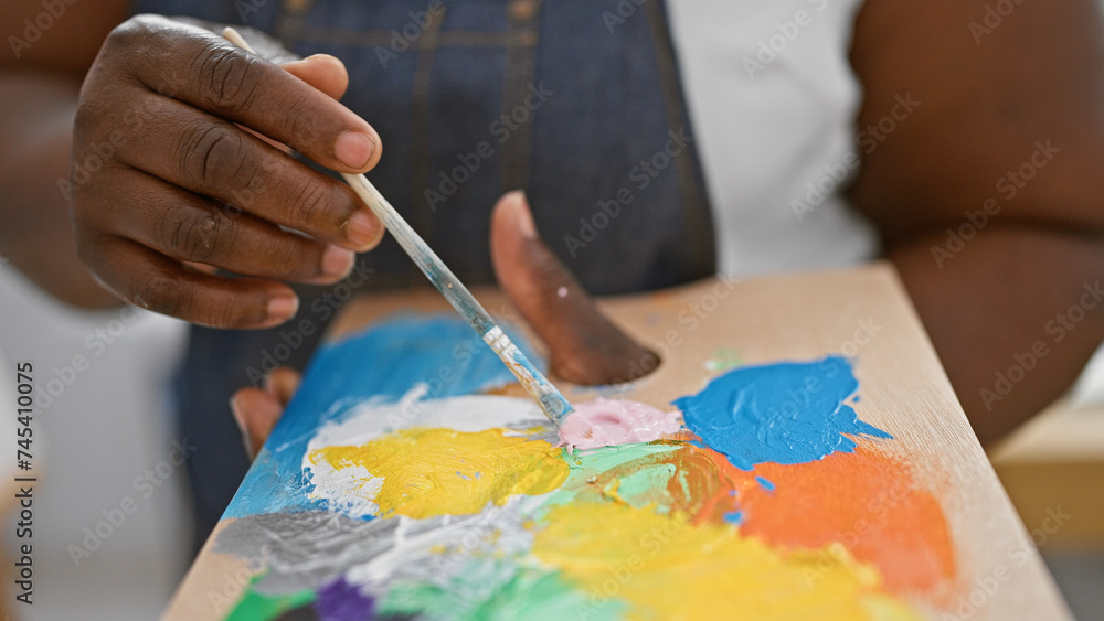 Creative hands of an african american woman artist passionately mixing color on palette in a buzzing art studio Creative hands of an african american woman artist passionately mixing color on palette in a buzzing art studio