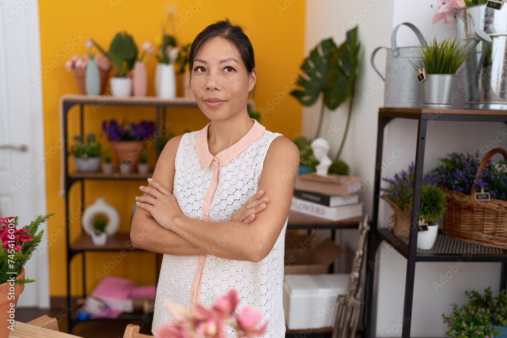 Young asian woman florist smiling confident standing with arms crossed gesture at flower shop