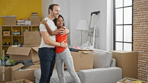 Beautiful couple hugging each other looking around smiling at new home