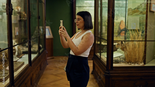 Young beautiful hispanic woman visiting natural history exhibition taking pictures at Natural History Museum in Vienna © Krakenimages.com