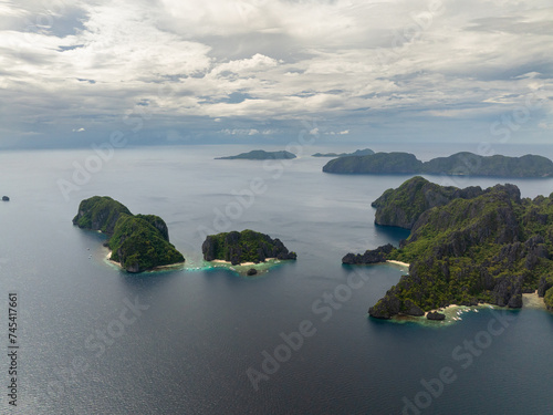 Twin Rocks with white sand and boats surrounded by blue sea. El Nido, Palawan. Philippines.