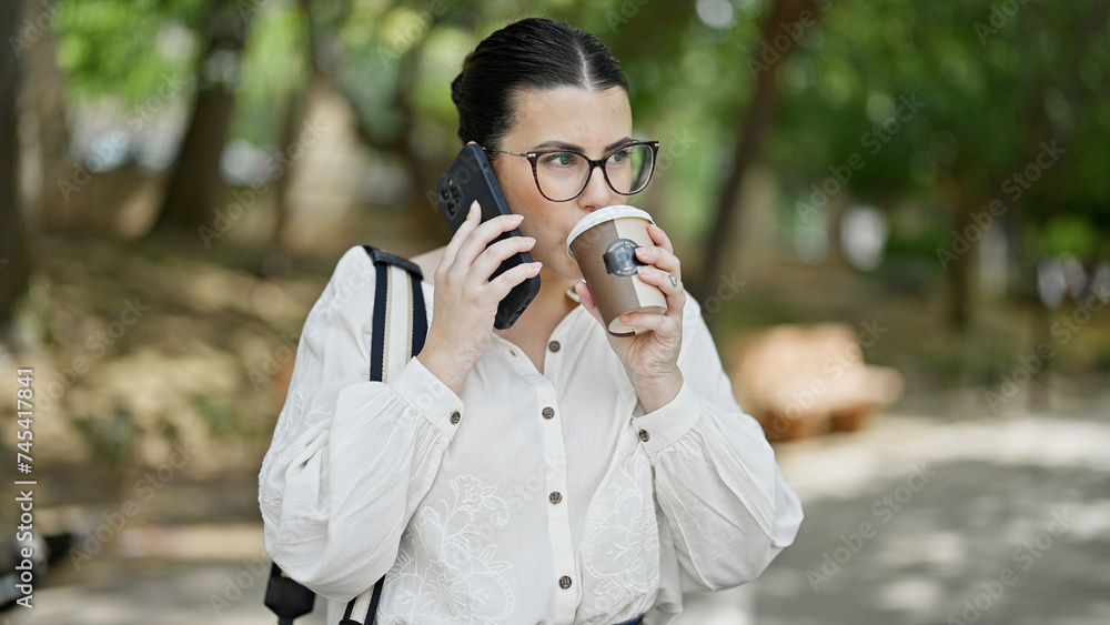 Young beautiful hispanic woman speaking on the phone drinking take away coffee at the park Young beautiful hispanic woman speaking on the phone drinking take away coffee at the park