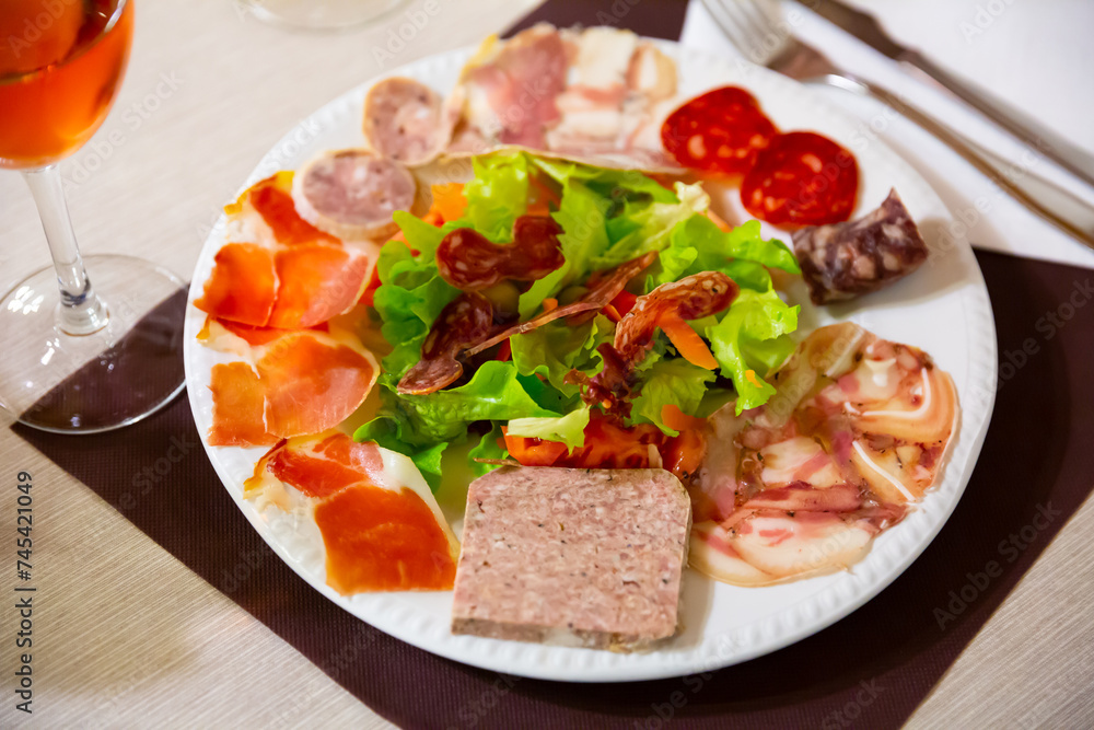 Image of a delicious Catalan salad dish of smoked meats, sausage, lettuce, tomatoes and meat on a plate...