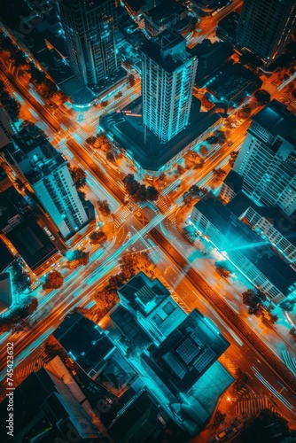 Bird's eye view of a city at night, illuminated by the glow of streetlights and car headlights