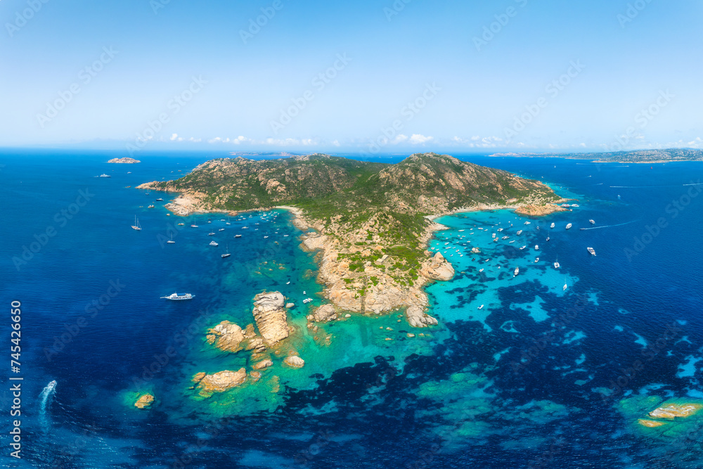 An island in the middle of the sea. Drone view of a yachts, boats and island. Vacationing people. Vacation and holidays. Summer time for sea travel. The sea bay. An island in the middle of the sea. Drone view of a yachts, boats and island. Vacationing people. Vacation and holidays. Summer time for sea travel. The sea bay.