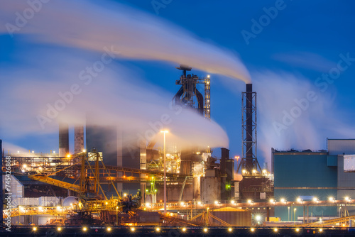 Oil refining. Heavy industry. View of production and factory. View of the factory at night. Emission of harmful substances into the atmosphere. Photo for background, advertising and wallpaper.