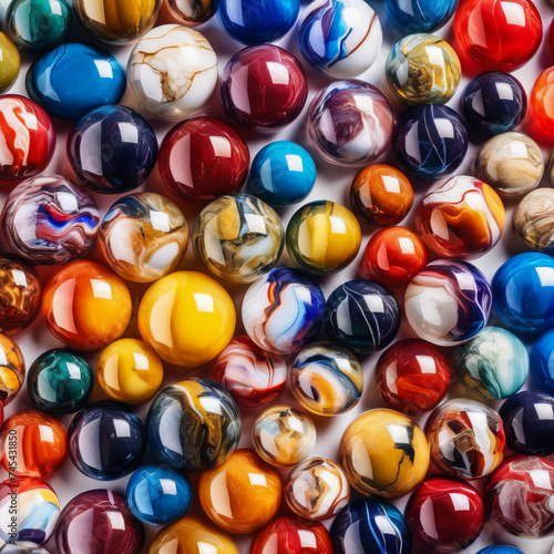 A collection of colorful marbles, big and small, jumbled together on a white background.