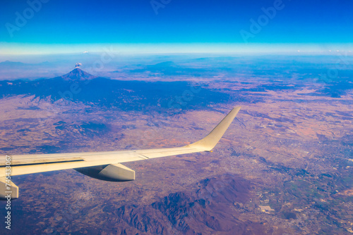 Fototapeta Naklejka Na Ścianę i Meble -  Flying airplane over Mexico Clouds Sky Volcanoes Mountains City desert.