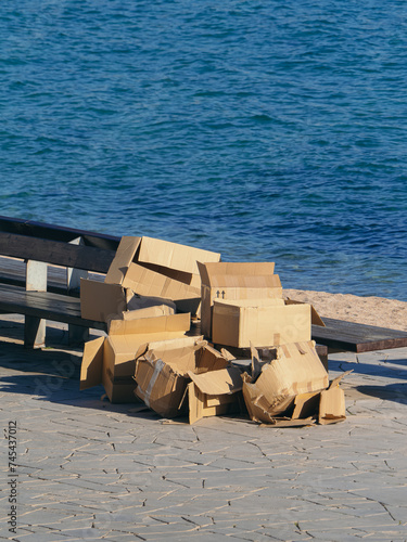 Pile of Discarded Cardboard Boxes on Seaside Promenade