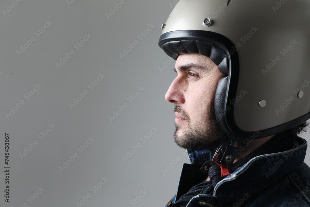 Close-up portrait of bearded man wearing helmet and black jacket posing indoor. Close-up portrait of bearded man wearing helmet and black jacket posing indoor.