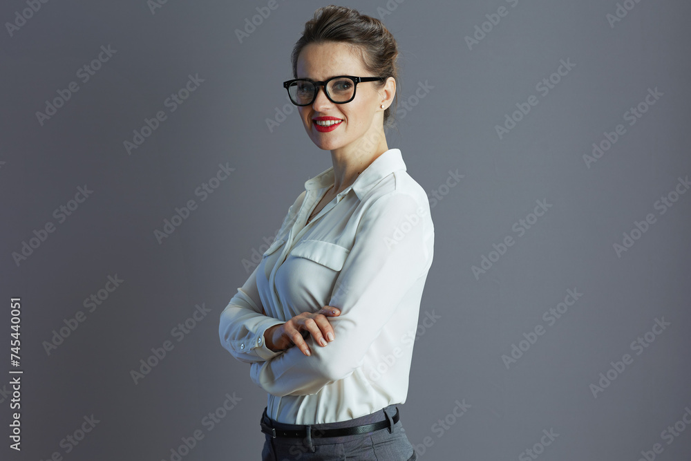 happy trendy 40 years old woman employee against gray