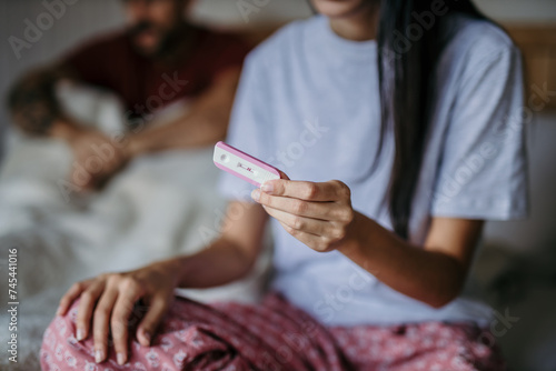 Anxious man and woman having a serious conversation with a pregnancy test in hand