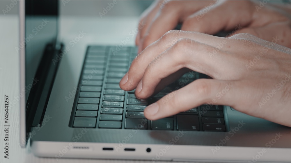 Man hands typing on laptop close up. Online project, report research at desk. Planning, business, freelancer student using laptop studying online working from home in internet. Blue toning side view Man hands typing on laptop close up. Online project, report research at desk. Planning, business, freelancer student using laptop studying online working from home in internet. Blue toning side view