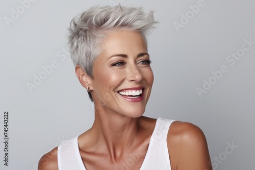 Portrait of a happy mature woman with short white hair smiling at the camera