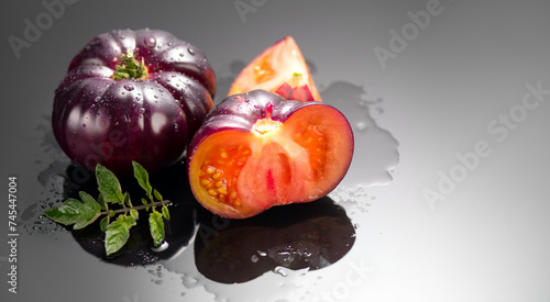 Black tomato, fresh ripe natural bio tomatoes close-up. Tasty organic Black Beauty tomato with leaves and water drops on black background. Close up. Garden, Gardening concept. © Subbotina Anna