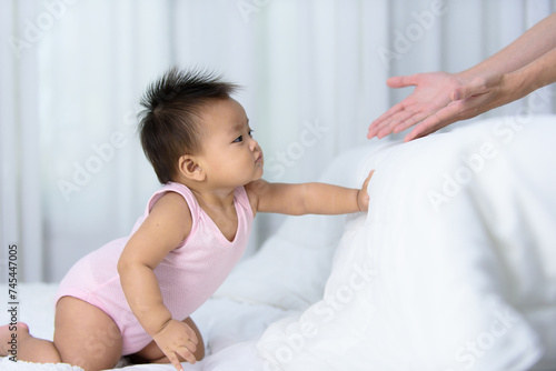 Asian baby crawl on white bed