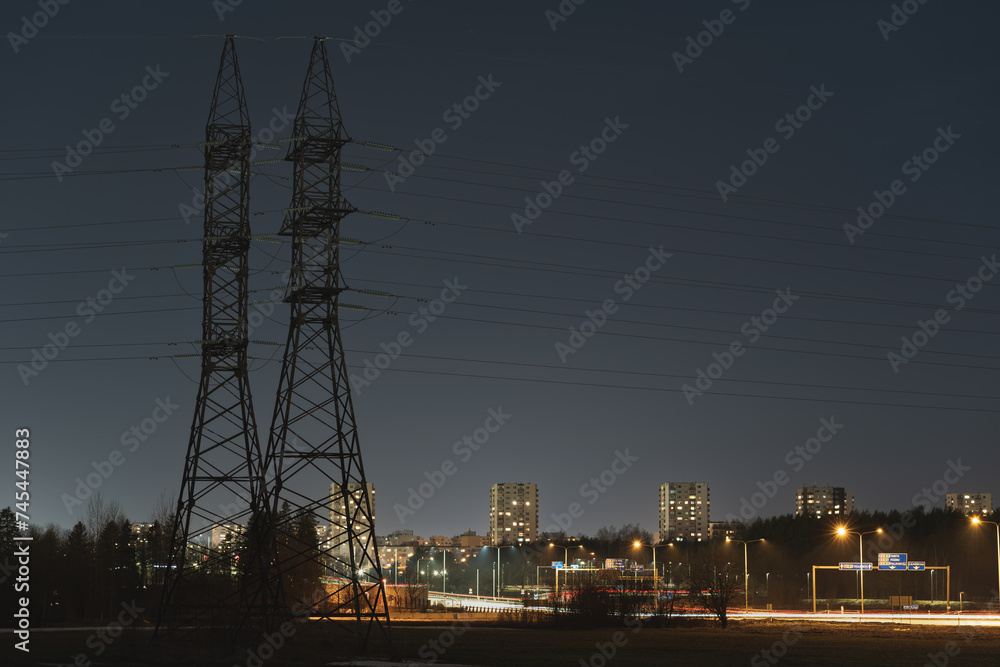 Night photo. Electric transmission lines against the backdrop of the night city and highway, Tallinn.