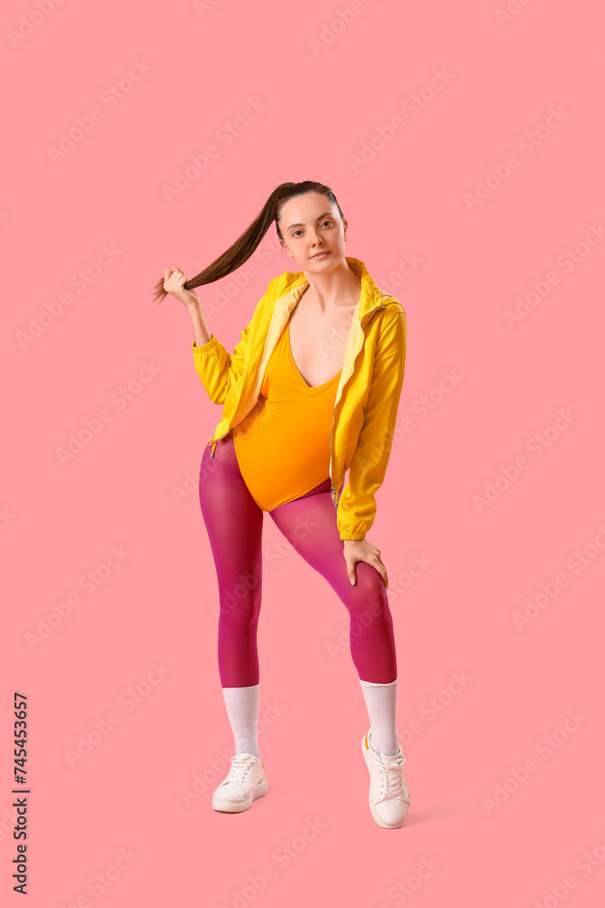Stylish sporty young woman on pink background Stylish sporty young woman on pink background