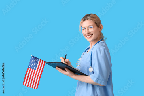 Female doctor with USA flag writing in clipboard on blue background