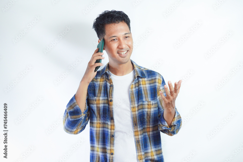 Adult Asian man laughing happy when answering a mobile phone call Adult Asian man laughing happy when answering a mobile phone call