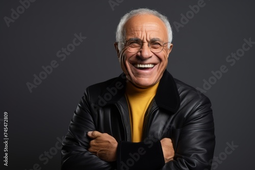 Portrait of a smiling senior man in black leather jacket and eyeglasses.