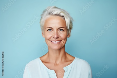 Portrait of a beautiful mature woman smiling at camera against blue background