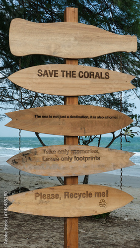A wooden placard or wooden signage is placed on the seaside of the beach with words that say 