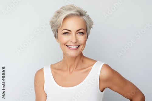 beauty, people and health concept - smiling middle aged woman in blank white t-shirt over grey background