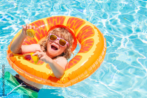 Fun child portrait. Kid boy relaxing in pool. Child swimming in water pool. Summer kids activity, watersports.