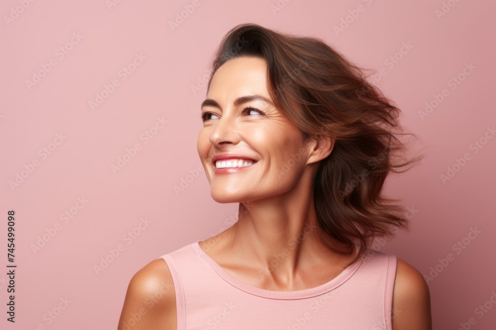 Portrait of a happy young woman looking up over pink background. Portrait of a happy young woman looking up over pink background.