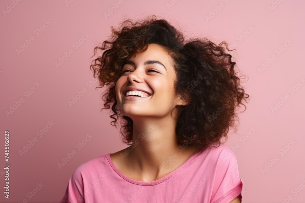 Portrait of a beautiful young woman laughing and looking up over pink background Portrait of a beautiful young woman laughing and looking up over pink background