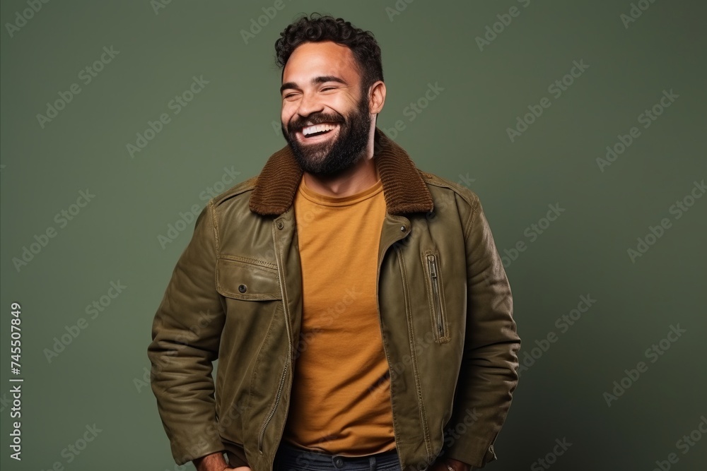 Portrait of a smiling young man in a leather jacket against a green background Portrait of a smiling young man in a leather jacket against a green background