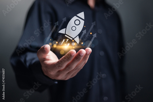 Startup business concept. Strategic planning and business success. Person holding rocket icon and up arrow on virtual screen for fast start up business.