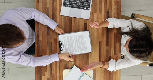 Unsure of the integrity of business agreement woman entrepreneur refuses to sign contact with businessman in office top view