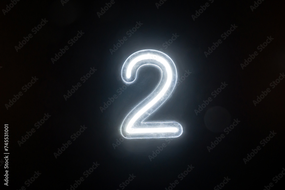 Number two glowing on the dark background. Close up of bright number 2 Number two glowing on the dark background. Close up of bright number 2