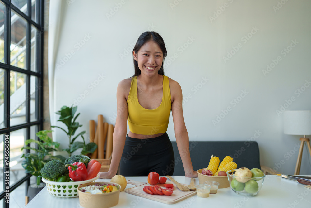 Beautiful young woman in exercise clothes preparing vegetable salad in the kitchen, healthy food Vegetarian salads, ideas, fasting, food selection, healthy lifestyle, cooking at home. Beautiful young woman in exercise clothes preparing vegetable salad in the kitchen, healthy food Vegetarian salads, ideas, fasting, food selection, healthy lifestyle, cooking at home.