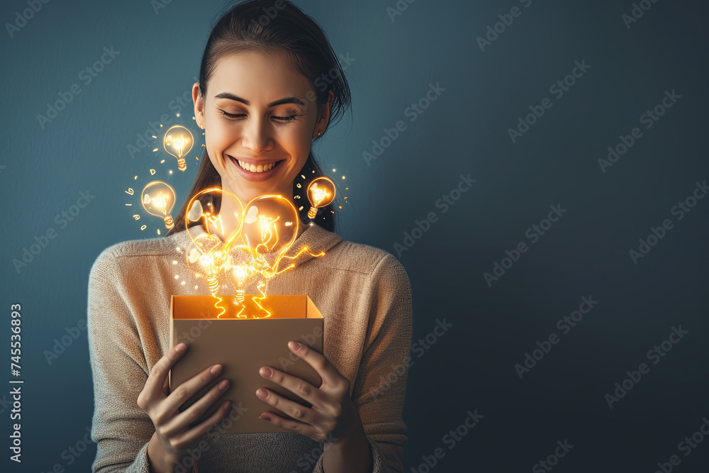 young happy woman holding a box with brilliant ideas spreading knowledge - obrazy, fototapety, plakaty 