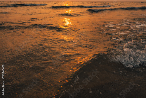 Sunset on the beach Golden sea waves at sunset