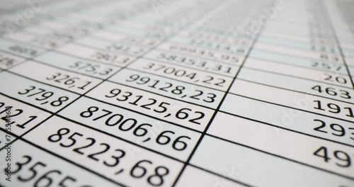 Document with columns of numbers on table in office