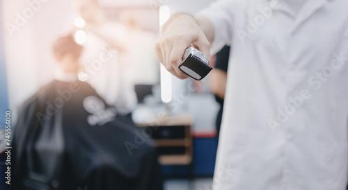 Barber shop banner. Closeup hairdresser holds hair clipper on barbershop background, with sunlight