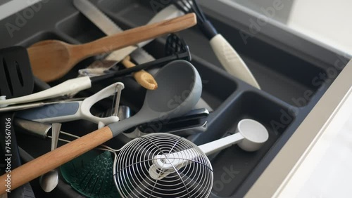 Close up of messy kitchen utensil drawer. photo