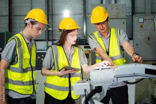 Engineer and technician discussing the robotic arm in factory about work operating, maintenance and repair