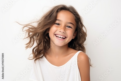 Portrait of a smiling little girl with long hair on white background