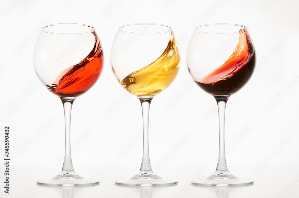 Rose, white, red wines splashes in stemware. Rose, white, red wines splashes in stemware.