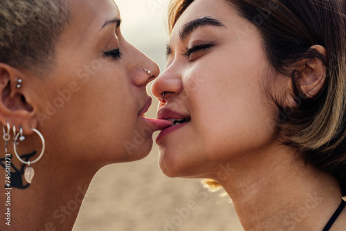 Beautiful multiethnic lesbian couple of lovers dating outdoors - LGBT people bonding and spending time together, concepts about LGBTQ community, diversity, love and lifestyle photo