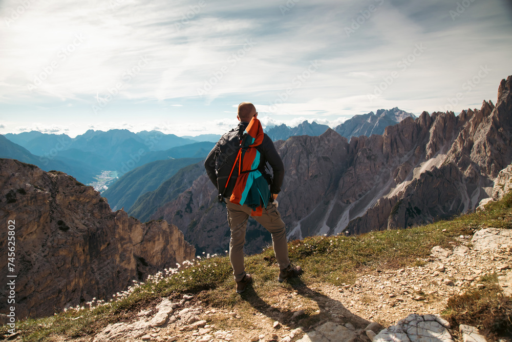 Stunning view of a tourist on the top of a hill enjoying the view of the Cadini di Misurina