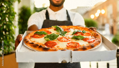 Pizza express delivery concept. Closeup of the hands of a delivery man  holding a pizza Margherita with mozzarella and tomato slices and basil green leaves  in a white cardboard box. Generative Ai.