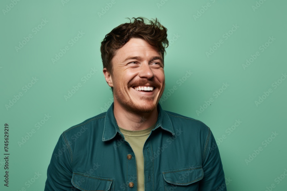 Portrait of a handsome young man laughing against a green background. Portrait of a handsome young man laughing against a green background.